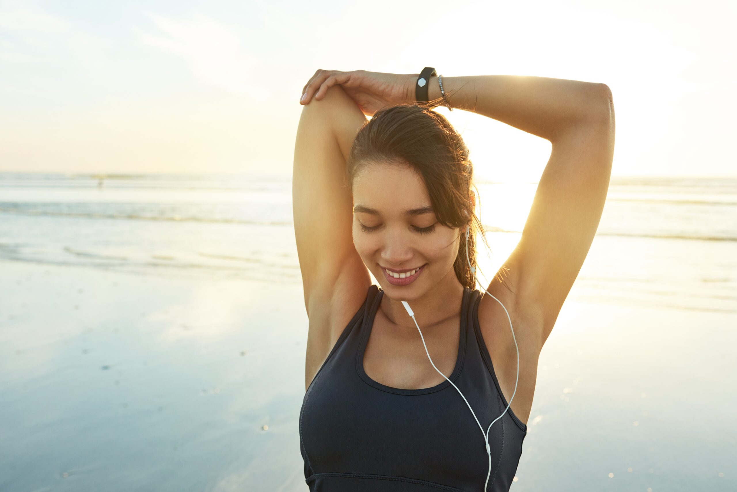 Woman who received depression treatment stretching by the beach