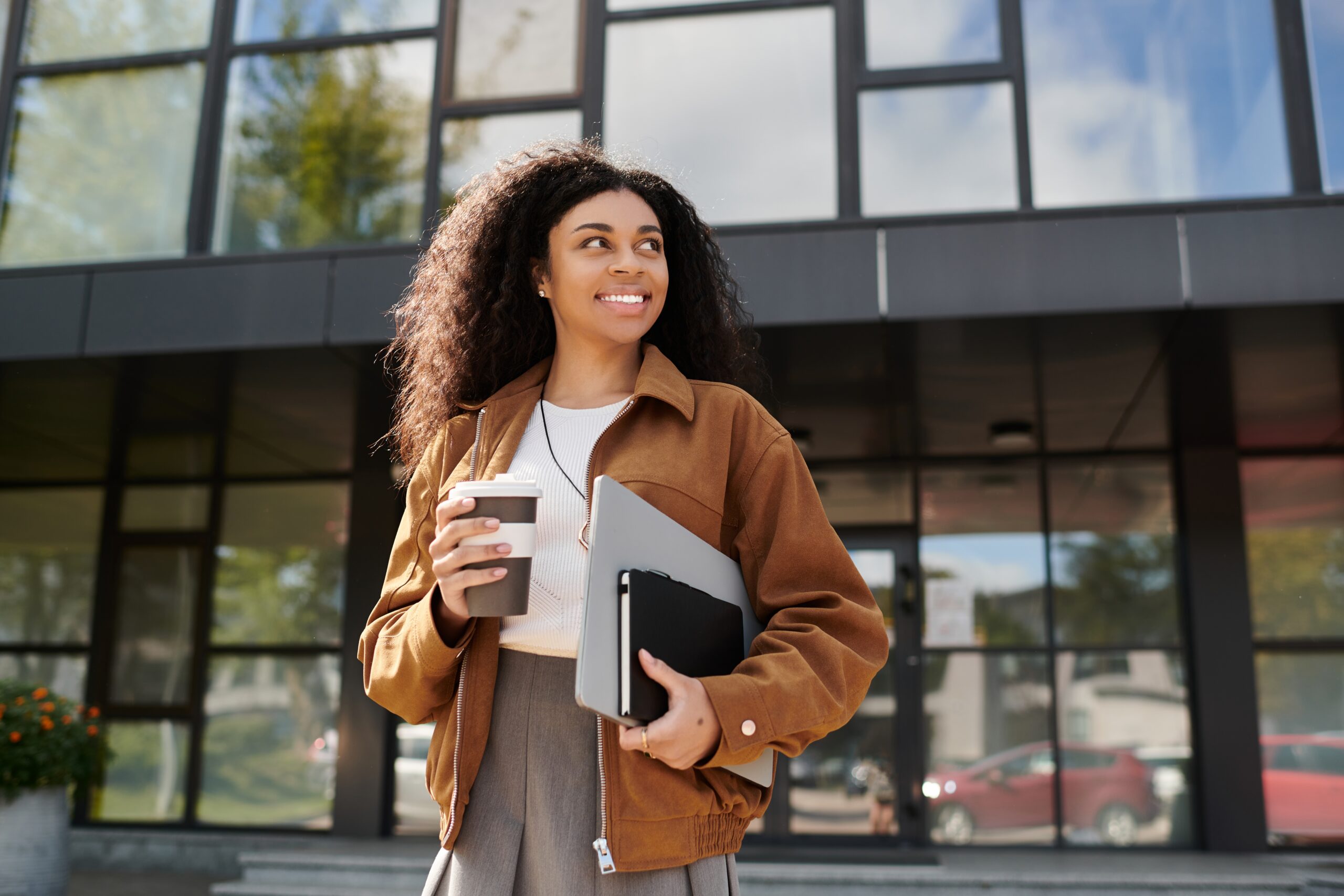 Woman with coffee in hand standing out building after receiving depression treatment in Plano, TX